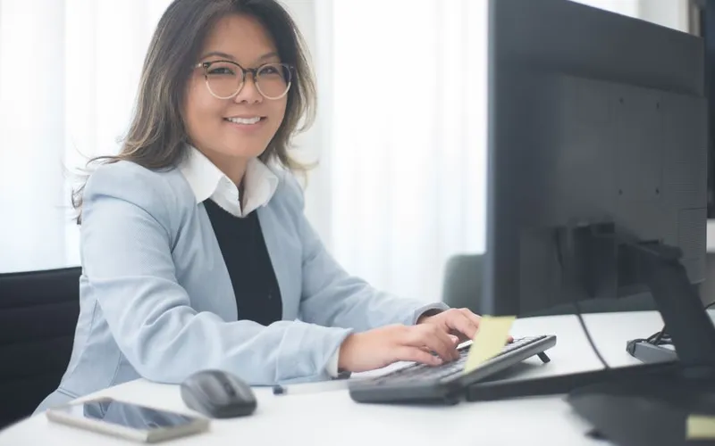 An office manager smiling at her computer