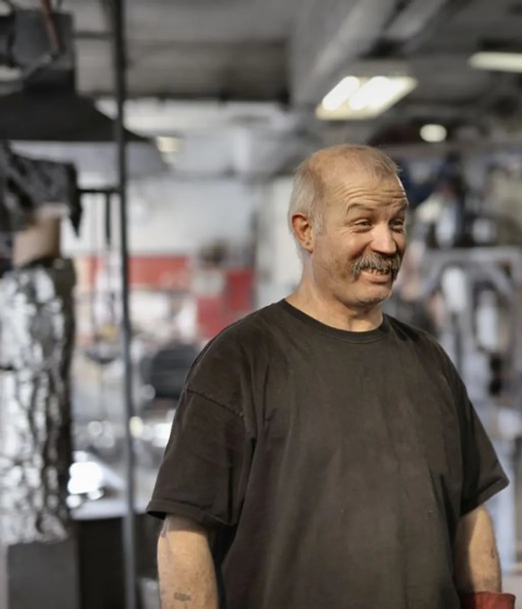 A shop owner smiling on his shop floor